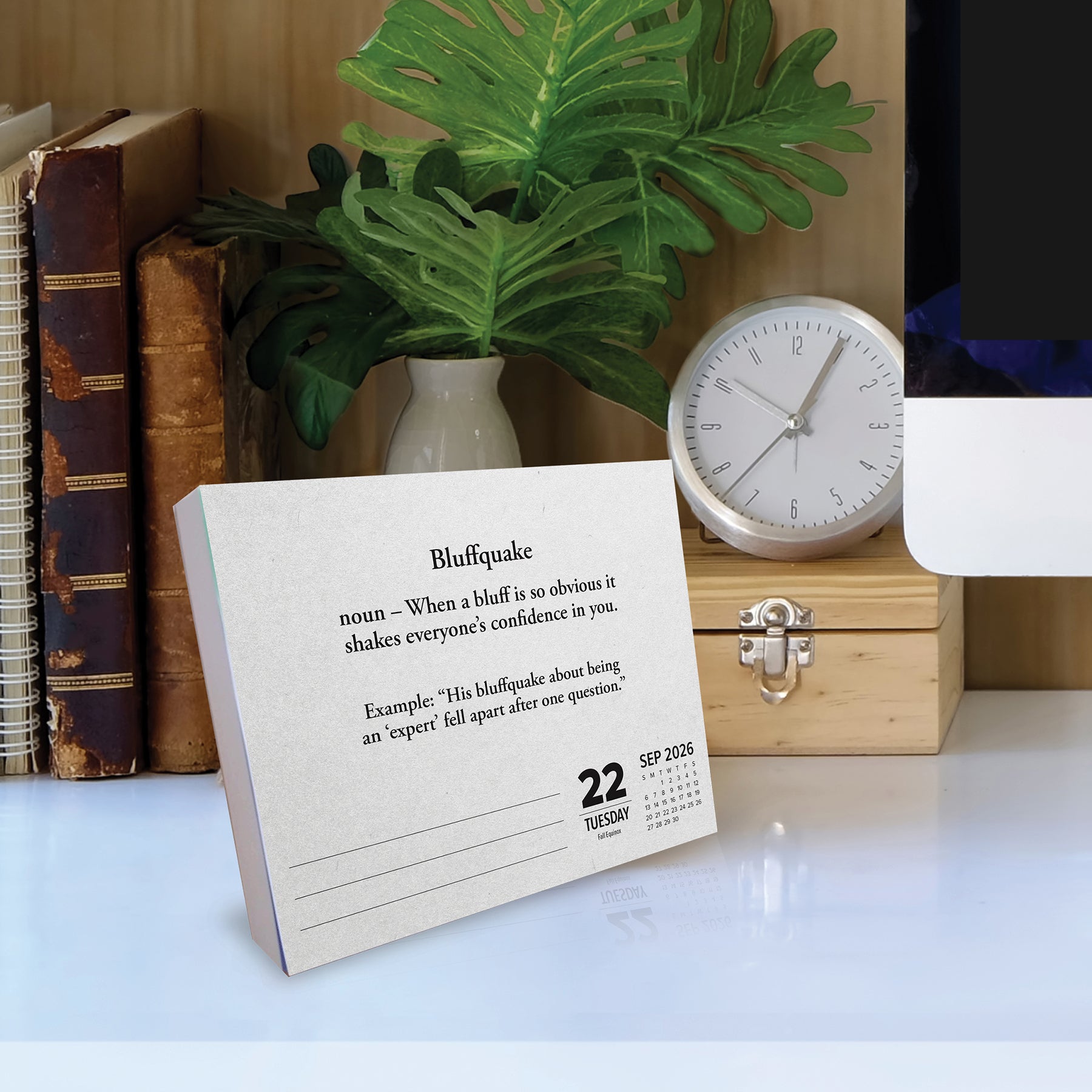 2026 Daily Box Calendar featuring the word 'Bluffquake' with a definition on a desk.