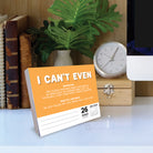 2026 Daily Box Calendar with Gen Z slang 'I Can't Even' definition on a desk with a clock and books.