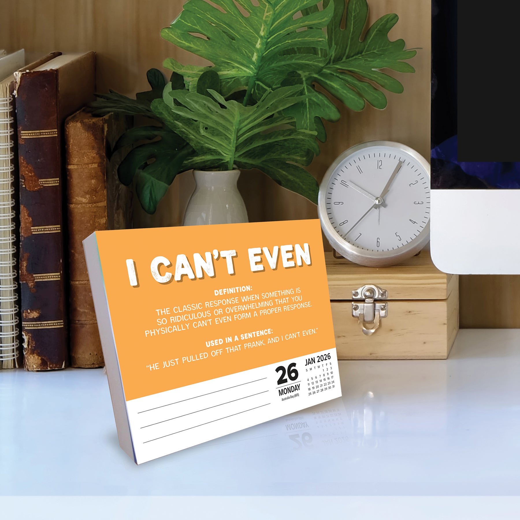 2026 Daily Box Calendar with Gen Z slang 'I Can't Even' definition on a desk with a clock and books.